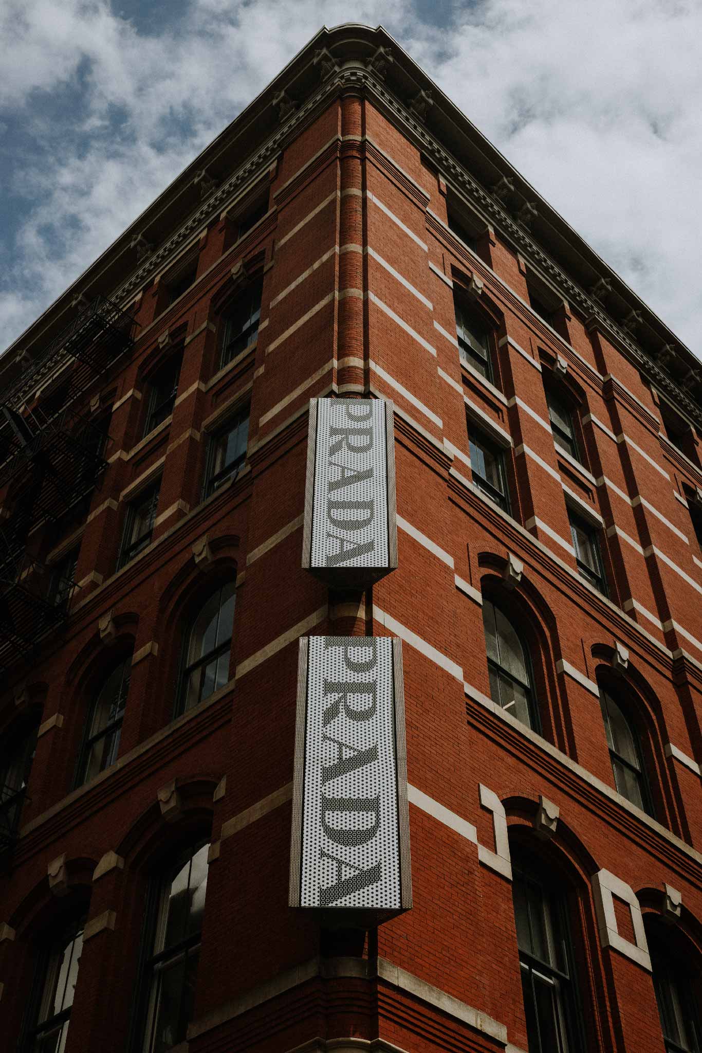 Prada NY by Will Salkeld, two vertical Prada signs on a red-brick SoHo cast-iron building, New York City architectural colour photography.