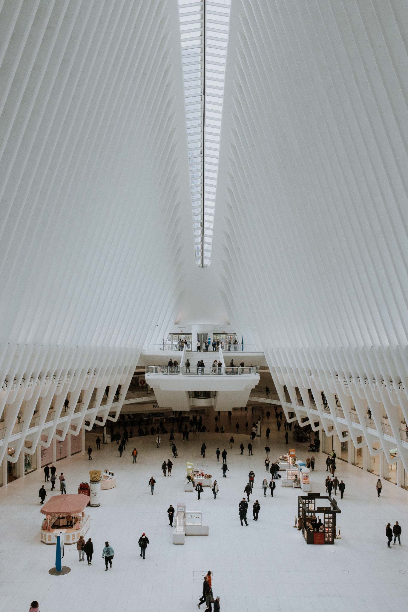 The Oculus by Will Salkeld, interior of the Calatrava Oculus at the World Trade Center with commuters on the marble floor, colour photography.