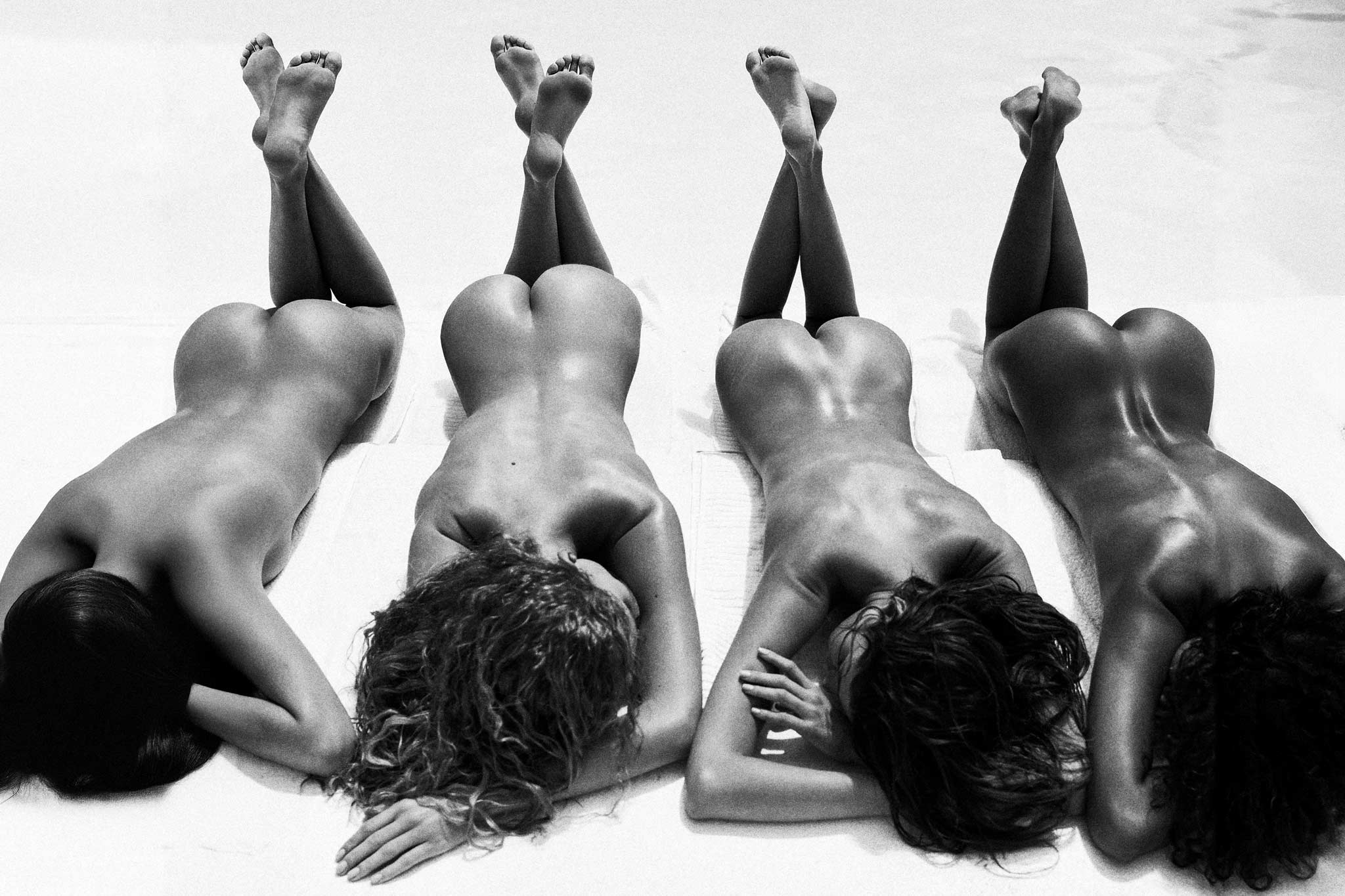 Cheeky Summer by Raex Murillo, black and white photograph of four nudes lying prone side by side, shot from above with legs folded up