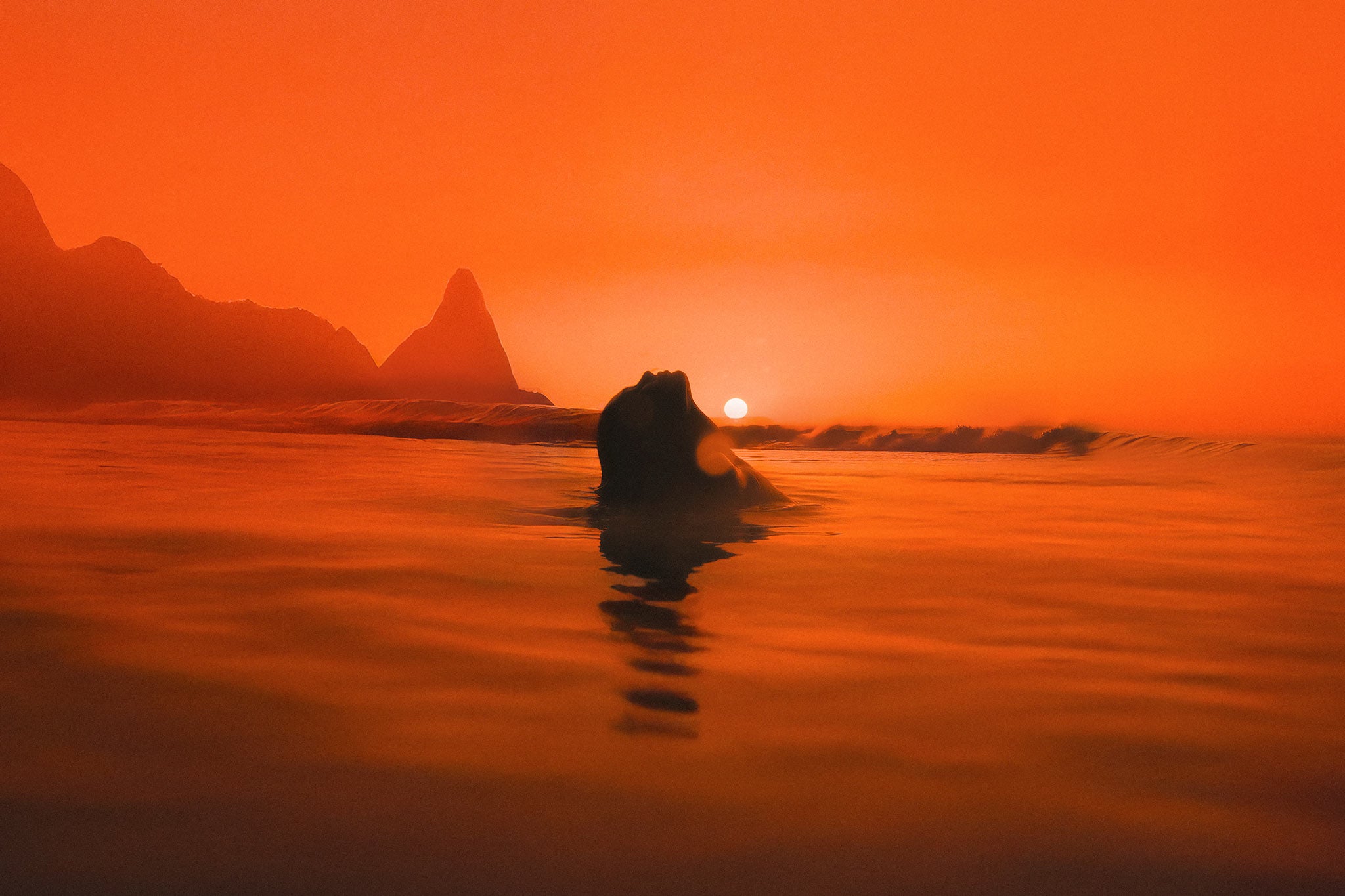Venus by Raex Murillo, colour photograph of a swimmer at chin height with the sun set against her temple at sunset