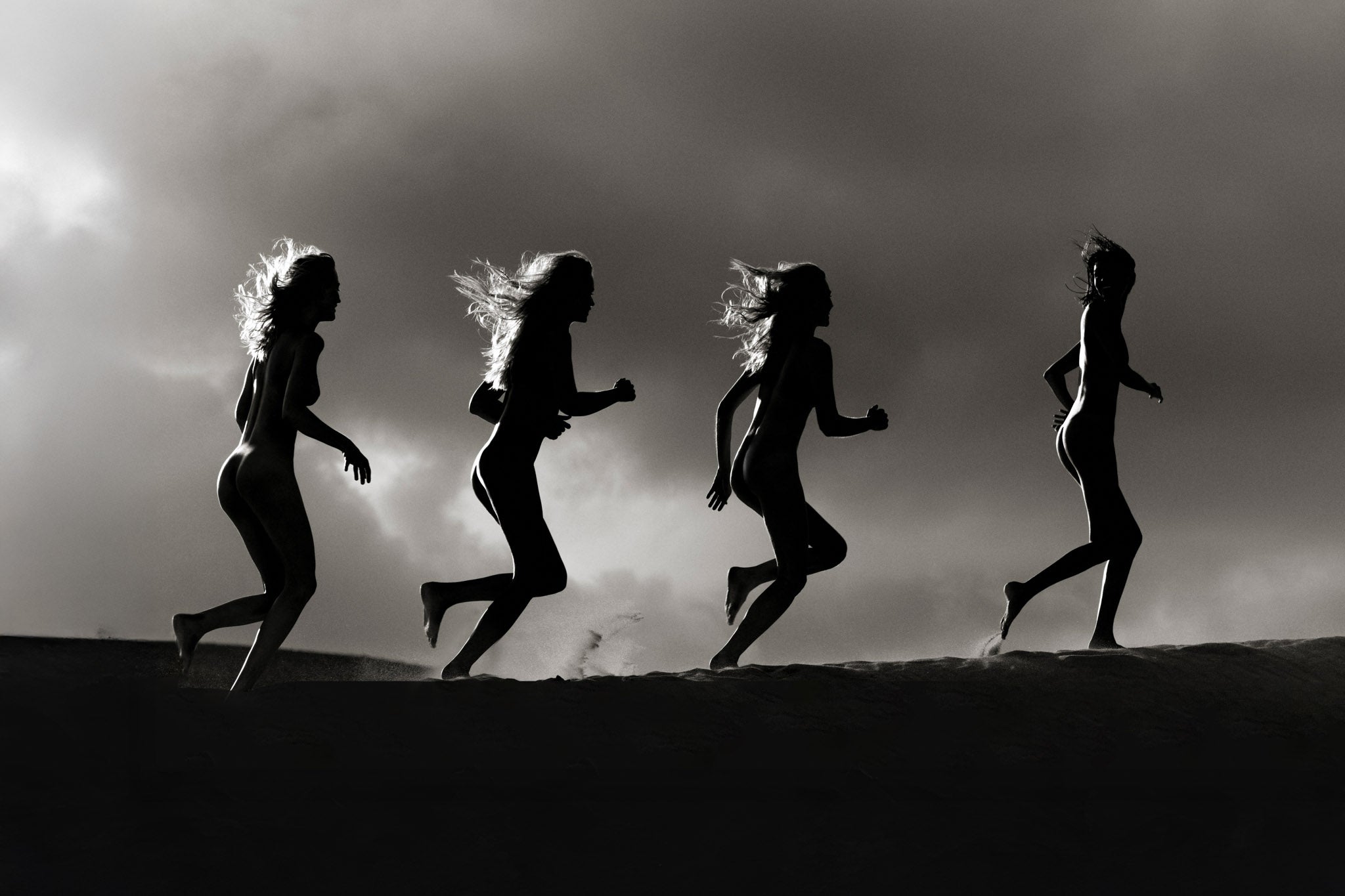 Into the Storm by Raex Murillo, framed black and white photograph of the human form in motion against open sky in silhouette and dramatic light