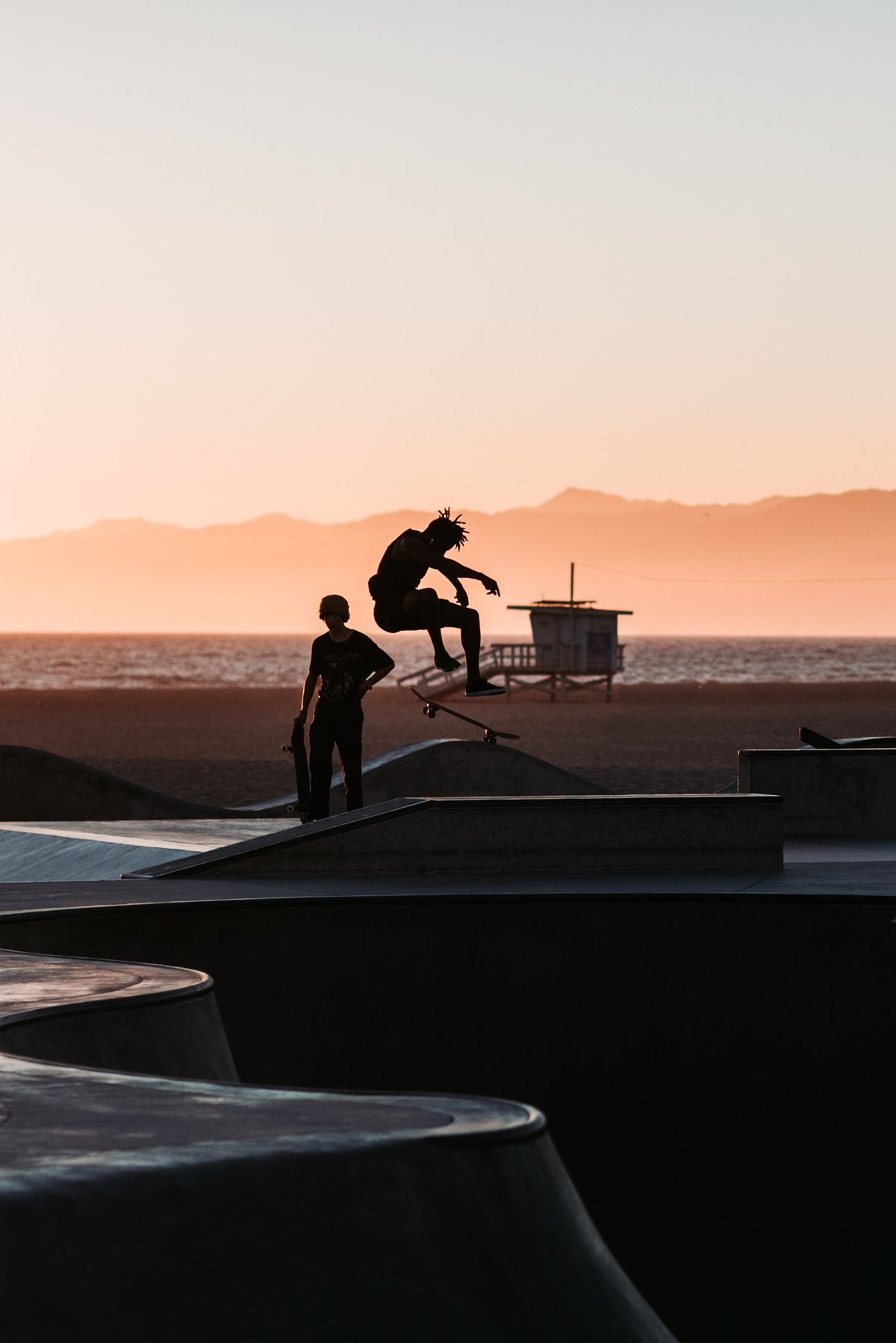Venice Ollie by Will Salkeld, colour photograph of a skateboarder silhouetted mid-air against the sunset at Venice Skatepark Los Angeles