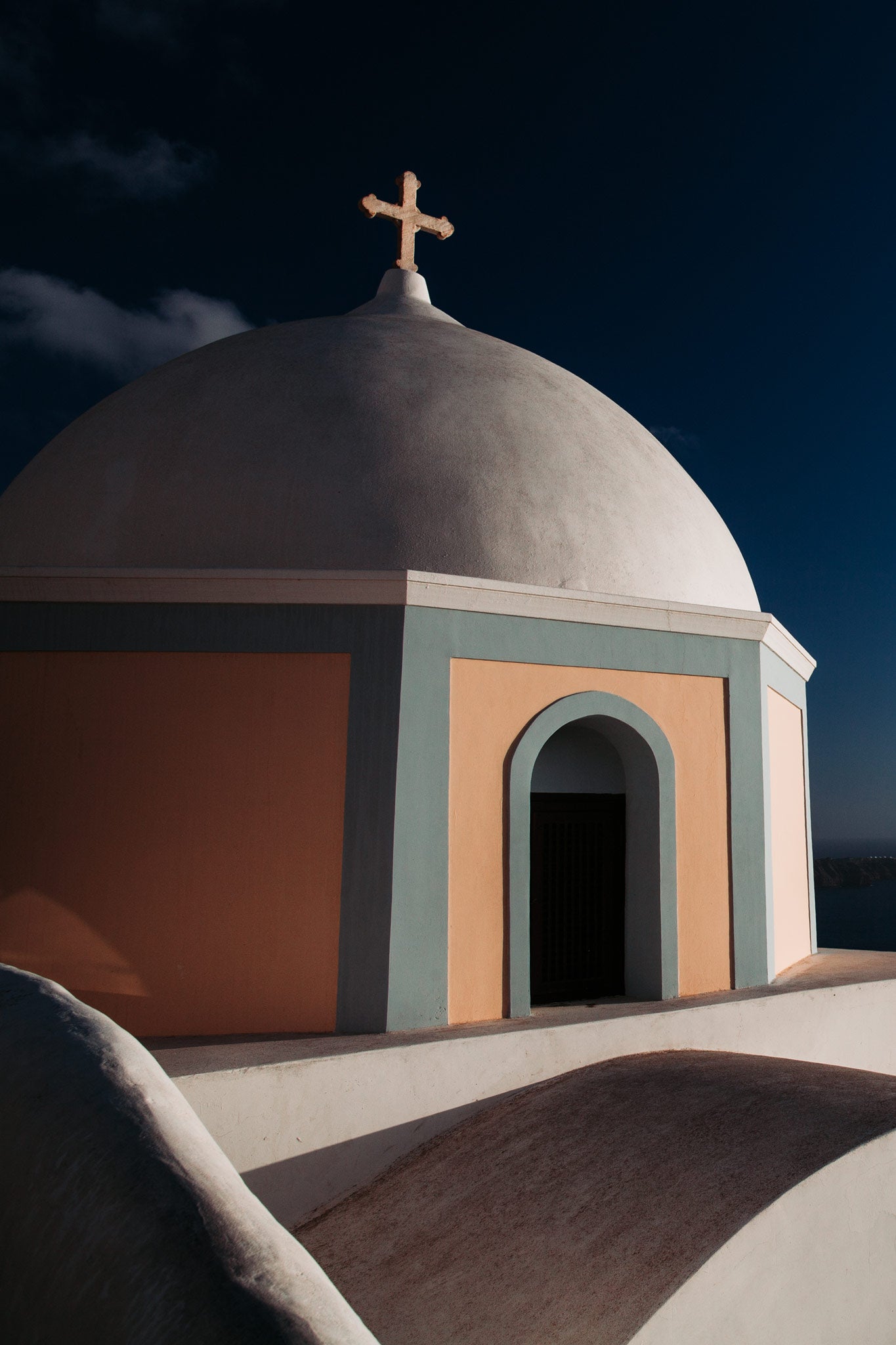 Aegean Chapel by Will Salkeld, colour photograph of a white-domed Greek Orthodox chapel with cross against deep blue Santorini sky